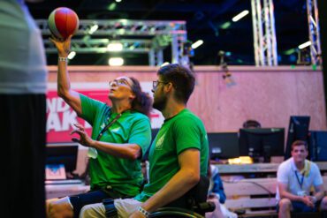 Ein Mann und eine Frau spielen Rollstuhlbasketball.